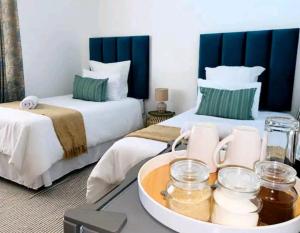 Cette chambre comprend 2 lits et un plateau/bouilloire. dans l'établissement Listos Guest House, à Empangeni