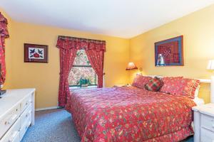 a bedroom with a red bed and a window at 107 McCloud - Highly Sought After Complex in Incline Village