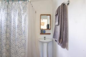 a bathroom with a sink and a mirror at La Canasta in El Zonte