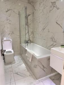 een badkamer met een bad, een toilet en een wastafel bij Ideal for Contractors in Reading with Free Parking in Reading