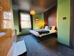 een slaapkamer met groene muren en een bed erin bij Park Mount Residences - Boutique 1 Bedroom Apartment In Leeds With Free Parking in Kirkstall