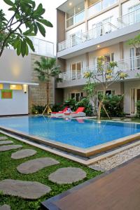 a swimming pool in front of a building at Choice Stay Hotel Denpasar in Denpasar