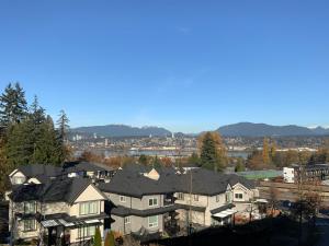 a group of houses in a city with mountains in the background at Cozy Living in Surrey