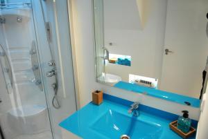 ein Badezimmer mit blauem Waschbecken und Dusche in der Unterkunft Blue Home in Santiago de Compostela