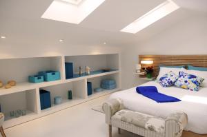 1 dormitorio con 1 cama blanca grande con almohadas azules en Blue Home, en Santiago de Compostela