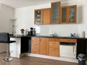 a kitchen with wooden cabinets and a black counter top at Helle & ruhige Wohnung in Neu-Ulm in Neu-Ulm
