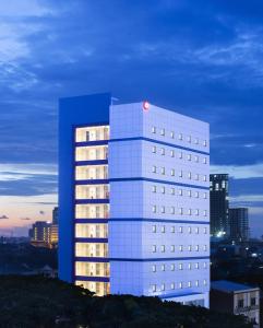 un grand bâtiment blanc avec une lumière rouge dans l'établissement Amaris Hotel Hertasning, à Makassar