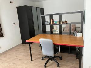 una oficina con un escritorio con una silla y un estante en Helle & ruhige Wohnung in Neu-Ulm en Neu-Ulm