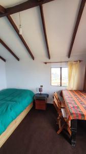 a bedroom with a bed and a table in a room at Ecolodge El descanso in Comunidad Yumani