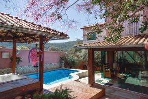 un patio trasero con piscina y una casa en CASA SPA Pirenópolis casa inteira en Pirenópolis