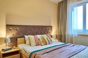 ein Schlafzimmer mit einem großen Bett und einem großen Fenster in der Unterkunft Elite Lux Apartment with balcony in Mukatschewo