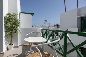 een balkon met een tafel en stoelen op een gebouw bij Casa Turquesa, shared pool in Puerto del Carmen