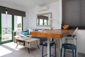 a kitchen with a counter with two stools and a table at Casa Turquesa, shared pool in Puerto del Carmen