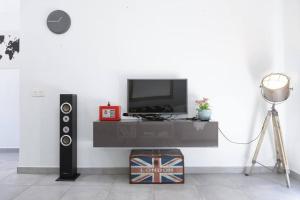 a room with a television and a table with a speaker at Casa Turquesa, shared pool in Puerto del Carmen