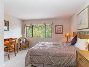 a bedroom with a bed and a desk and a window at Incredible Lake Tahoe Views 2 Master Suites and a Loft in Incline Village
