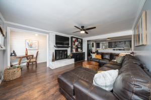 a living room with a leather couch and a fireplace at Colleens Corner Captivating 4bed 2.5 bath in Charming Neighborhood in Little Rock