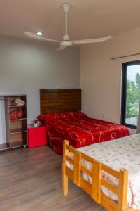 a bedroom with two beds and a red bedspread at Casa Biznaga in Oaxaca City