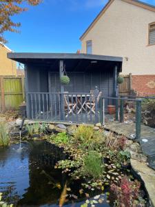 a house with a pond in front of a house at Geneva Cottage (Twin Room) in Darlington