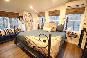 a bedroom with a bed in a room with windows at Secluded Treehouse in the Woods - Tree Hugger Hideaway in Branson
