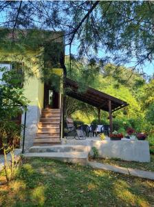 a house with a porch and stairs to a patio at Vikendica Alisa in Doboj
