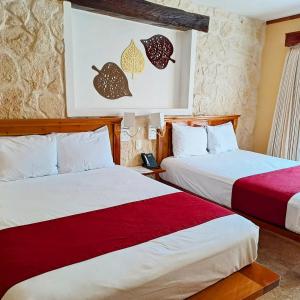 two beds sitting next to each other in a room at Cancun International Suites in Cancún +31 photos
