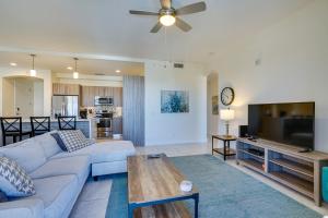 a living room with a couch and a flat screen tv at Modern Fort Myers Condo Rental about 5 Mi to Beach! in Fort Myers