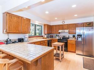uma cozinha com armários de madeira e um frigorífico de aço inoxidável em A great mountain home offering amenities that makes for a great getaway in Lake Tahoe em Incline Village