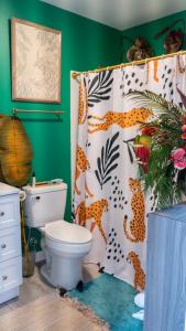 a bathroom with a toilet and a shower curtain at Tropical Tiki Hut in Louisville
