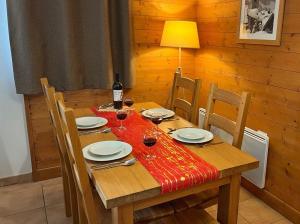 una mesa de madera con una botella de vino y copas en Time to Ski - Belle Vue, en Sainte-Foy-Tarentaise 3 fotos más