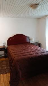 a bedroom with a bed with a red comforter at Casa do Freire - Serra da Estrela in Aguincho
