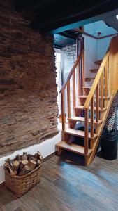 a wooden staircase in a room with a stone wall at Casa do Freire - Serra da Estrela in Aguincho