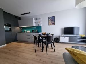 a kitchen and dining room with a table and chairs at ApartTargowa in Toruń