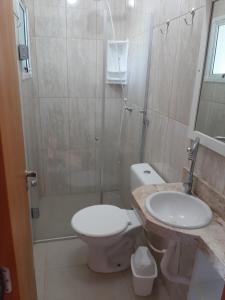 uma casa de banho com um WC, um lavatório e um chuveiro em Condomínio Cordeiro em Arroio do Sal