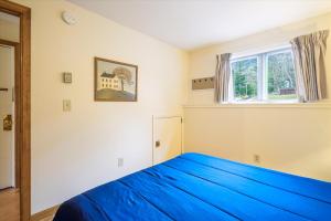 - une chambre avec un lit bleu et une fenêtre dans l'établissement Cozy one bedroom Edgemont B3 condo ski back trail, à Killington