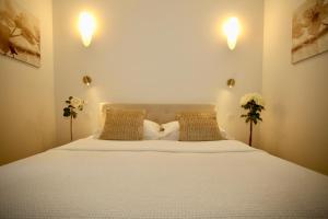 埃茲的住宿－Eze Villa，卧室配有一张带两个枕头的大白色床