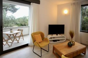 Eze Villa في إز: غرفة معيشة فيها تلفزيون وطاولة وكراسي