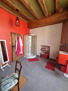 Cette chambre aux murs rouges comprend une salle de bains pourvue d'un réfrigérateur. dans l'établissement La chatellenie Gîte de caractère de 1638., à Évaux-les-Bains