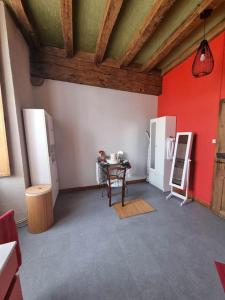 une cuisine avec une table et un mur rouge dans l'établissement La chatellenie Gîte de caractère de 1638., à Évaux-les-Bains