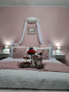 - un lit blanc avec un plateau de fleurs dans l'établissement La chatellenie Gîte de caractère de 1638., à Évaux-les-Bains