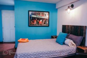 1 dormitorio con 1 cama con pared azul en Deluxe Room D1/Dakao en Ho Chi Minh