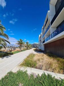 an empty street in front of a building with palm trees at 309 Waterfront in Werribee South