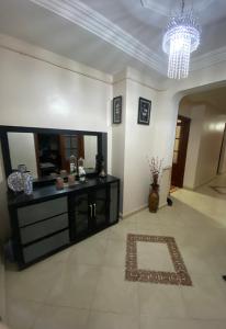 a living room with a chandelier and a large room at Appartement haut standing in Tlemcen