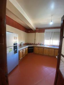 a kitchen with a white refrigerator and wooden cabinets at Appartement haut standing in Tlemcen