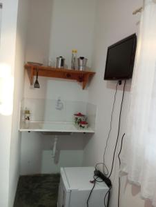 a small room with a television and a refrigerator at Pousada flor do sertão in Piranhas