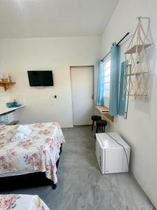 a room with two beds and a television in it at Pousada flor do sertão in Piranhas