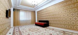 a living room with a red couch and a window at Жк Нурсая 2комн.апартаменты in Atyrau