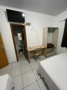 a room with a bedroom with a desk and a bed at Hotel BLESS in Cascavel