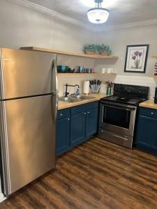 a kitchen with a stainless steel refrigerator and a stove at Indigo DowntownWalkable KingBed in Raleigh