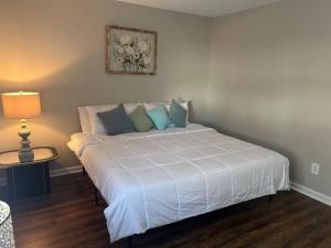 sypialnia z dużym białym łóżkiem z poduszkami w obiekcie Indigo DowntownWalkable KingBed w mieście Raleigh