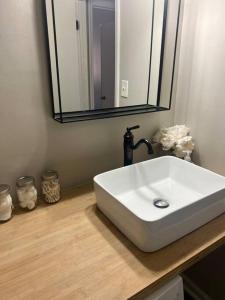 a bathroom with a white sink and a mirror at Indigo DowntownWalkable KingBed in Raleigh